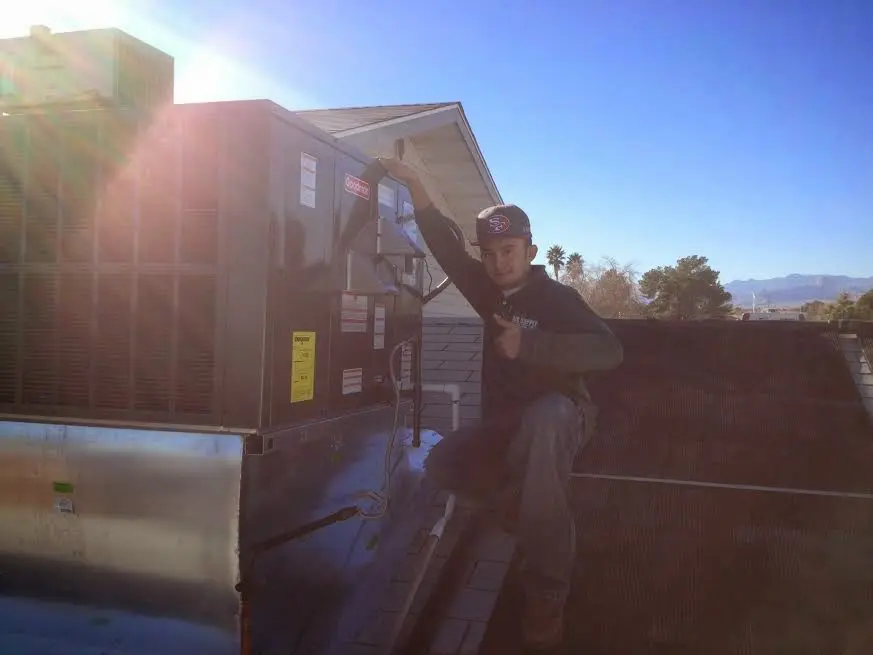 HVAC technician performing Air Duct Repair on a rooftop unit in Hobart